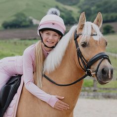 a woman riding on the back of a brown horse