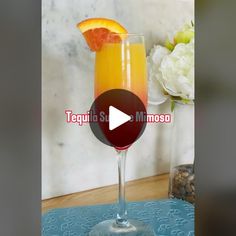 an orange and red drink in a tall glass on a blue mat with the words tequila so mimose