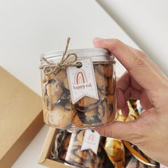 a hand holding a jar filled with cookies