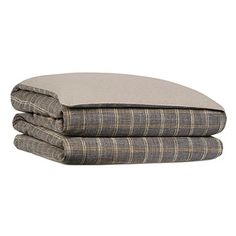 three pillows stacked on top of each other in front of a white background with the same plaid pattern