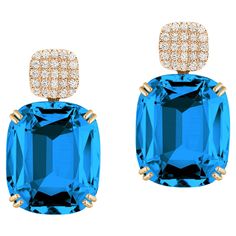 Introducing the stunning London Blue Topaz Cushion & Diamonds Earrings from our popular 'Gossip' Collection. The focal point of these earrings is the mesmerizing London Blue Topaz cushion-cut gemstone. The cushion-cut shape adds a touch of vintage charm, while the vibrant color of the London Blue Topaz exudes a captivating allure. The gemstone is carefully faceted to enhance its brilliance and maximize its natural beauty. O the top of the London Blue Topaz gemstone you can find dazzling diamonds, which add a touch of sparkle and sophistication to the overall design. The diamonds are meticulously set in 18K yellow gold, creating a beautiful contrast against the London Blue Topaz. The craftsmanship of these earrings is impeccable, with attention to detail evident in every aspect. With their Cushion Diamond Earrings, Cushion Cut Diamond Earrings, Emerald Cut Diamond Earrings, Cushion Earrings, London Blue Topaz Earrings, Diamonds Earrings, Blue Topaz Stone, Blue Topaz Earrings, Cushion Diamond