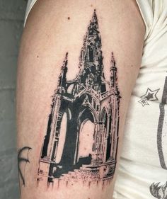 a black and white photo of a cathedral tattoo on the left upper half of the arm