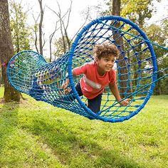 a young boy is playing in a blue hammock