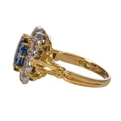 From our estate & antique collection, this English-made Victorian-style reproduction cluster engagement ring features a cushion sapphire center stone secured by 18K yellow gold prongs, surrounded by 10 Old European cut diamonds secured by prong and milgrained bezel settings in platinum, with an 18K yellow gold shank featuring ornate engraving. Total sapphire weight: 2.37 ct Shape: Cushion-Cut Color: Slightly violet-blue hue, medium tone, strong saturation Clarity: Eye Clean Total diamond weight: Victorian Sapphire Ring With Center Stone, Victorian Sapphire Ring In Yellow Gold, Victorian Multi-stone Cluster Ring, Luxury Victorian Yellow Gold Sapphire Ring, Luxury Victorian Sapphire Ring Collectible, Milgrain Ring, Cluster Engagement Ring, European Cut Diamonds, Diamond Cluster Ring