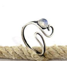 "Adjustable moonstone ring, Moonstone silver ring, Bohemian jewelry, Boho rings, Open ring. This everyday ring comes in many difrent stones 🌸 Features: Handmade ring 🌸 Measurements: Weight - 1.8g Width of the ring at the top - 0.57\" (1.45 cm) Stone diameter - 0.2\" (5 mm) 🌸Materials: Sterling Silver Moonstone 🌸 More info: All my jewelry is carefully wrapped and shipped in a lovely gift box, ready to be given as a gift. ♥ For the same ring design with a garnet, click here: www.etsy.com/listi Adjustable Moonstone Crystal Ring With Open Design, Silver Moonstone Stackable Open Rings, Unique Adjustable Moonstone Ring, Adjustable Spiritual Moonstone Toe Ring, Adjustable Silver Moon-shaped Moonstone Ring, Handmade Silver Moonstone Toe Ring, Adjustable Silver Moonstone Toe Ring, Adjustable Moonstone Open Stackable Rings, Adjustable Silver Moonstone Crystal Ring