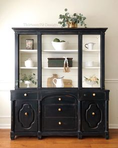 a black china cabinet with glass doors and drawers