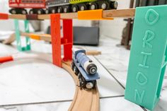 a toy train is coming down the track in front of a sign that says brighton