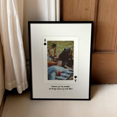 a photo frame sitting on the floor next to a door with an ace playing card in front of it