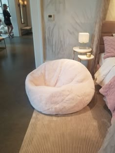 a dog bed sitting on top of a rug next to a white chair and table