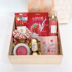 a pink box filled with lots of different types of things to eat and drink for valentine's day