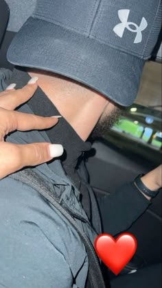 a woman with her hand on the seat of a car, wearing a baseball cap