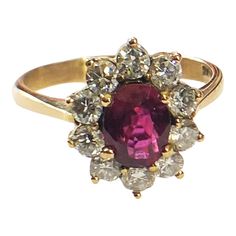 This breathtaking 18K Yellow Gold Ruby & Diamond Ring offers an exquisite 18k gold mounting, including a 2.5mm shank center that showcases an elegantly prong-set medium-grade oval ruby at approximately 1.04 carats. The ruby measures 7.2 x 5.3 x 3.34 mm. The ring is adorned with 10 full-cut, 2.6 mm, 07 point diamonds of JK color and VS clarity. The gold weight of the ring is 2.5 dwt /3.88 grams and is presented in a finger size of 8.5. Marked. Exquisite Oval Ruby Ring With Center Stone, Formal Oval Ruby Ring With Center Stone, Classic Ruby Ring With Pear-shaped Stone, Formal Fine Jewelry Ruby Ring With Lab-created Ruby, Classic Oval Lab-created Ruby Diamond Ring, Formal Cluster Ring With Ruby Center Stone, Formal Ruby Cluster Ring With Center Stone, Oval Ruby Cluster Ring With Center Stone, Exquisite Ruby Ring For Formal Occasions