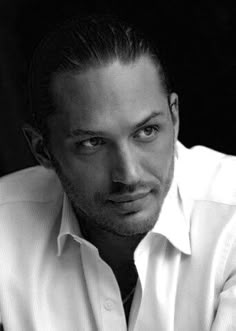 a man in a white shirt and tie is posing for a black and white photo