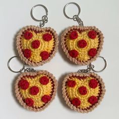 four crocheted keychains with slices of pizza in the shape of hearts