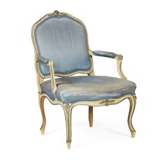 an antique chair with blue upholstered fabric and gold trimmings on the back