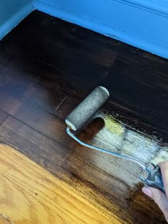 a person using a paint roller on the floor