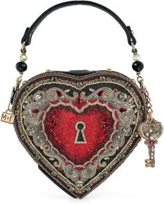 Mary Frances Embrace Top Handle Bag Spread love wherever you go with our heart-shaped locket handbag! Complete with a removable key charm and intricate filigree design, this top-handle bag is the perfect accessory for any occasion. DIMENSIONS: 8.5 x 2.25 x 8", Strap Length: 16.25", Strap Drop: 5.5", FEATURES: Non-removable top-handle, magnet closure, inside pocket, fits a phone, vegan leather THIS IS A HANDMADE ITEM, EACH ONE AN INDIVIDUAL WORK OF ART. SLIGHT VARIATIONS MAY OCCUR. I am a authorized retailer for Mary Frances Handbags  Must be returned as received in new condition as received with all the tags and wrappings ....Thank you   Enjoy and please leave me some great feedback! Queen Of Hearts Handbag, Mary Frances Handbags, Novelty Handbags, Locket Design, Big Handbags, Novelty Purses, Fran Fine, Mary Frances, Heart Pocket