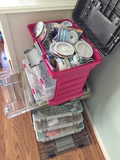 a pink cart filled with lots of items on top of a hard wood floor