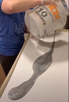 a woman is pouring water into a container on top of a counter with spoons