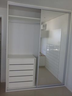 an empty room with white walls and drawers