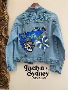 Cheer Coach Jean Jacket, Denim Jacket With Patches Diy, Cheer Jean Jacket, Cheer Coach Outfit Style, Painted Jean Jacket School Spirit, Senior Jean Jacket, Cheer Letterman Jacket, Cheer Coach Outfit, College Jean Jacket