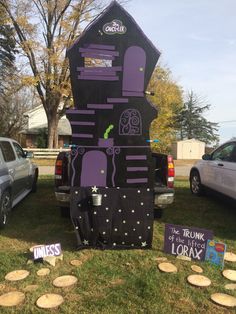 a purple and black house made out of cardboard sitting in the grass