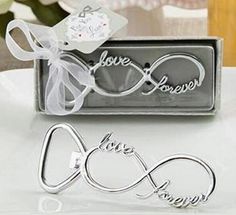 two pieces of silver metal with the word love and an infinite sign on them, sitting on a white plate