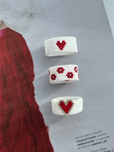 three bracelets with hearts on them sitting on top of a piece of paper next to a napkin