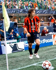 a soccer player on the field with a ball in front of an orange and black uniform