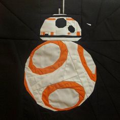 the star wars quilt is made to look like an orange and white bb - 8