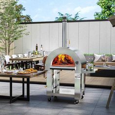 an outdoor pizza oven sitting on top of a patio next to tables with chairs around it