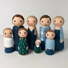 a group of wooden dolls standing next to each other in front of a white background