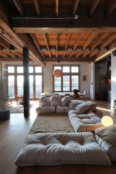 a living room filled with lots of furniture next to a fire place and large windows