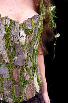 a woman in a corset with moss growing on it