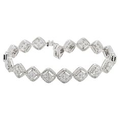 Elegance meets high-end style in this exquisite diamond halo bracelet, crafted from 18KT white gold. This luxurious piece features shimmering square cushion clusters of round-shaped diamonds, each cluster encircled by a dazzling halo setting that amplifies the light and brilliance of the stones. The total diamond weight of this stunning bracelet is 4.68 carats, making it a significant statement of opulence and glamour. The design seamlessly combines the classic charm of cushion cuts with the modern allure of halo settings, creating a fun and stylish piece that's perfect for any occasion. Whether it's a glamorous evening event or a sophisticated daytime gathering, this bracelet is sure to catch the eye and light up the room with its spectacular sparkle. The 18KT white gold setting enhances Square Diamond Bracelet, Formal Diamond White Diamond Bracelet With Pave Setting, White Diamond Bracelet With Pave Setting For Formal, Formal White Diamond Bracelet With Pave Setting, Luxury Diamond Bracelet With Halo Setting, Luxury Tennis Bracelet With Halo Setting For Formal Events, Luxury Tennis Bracelet With Halo Setting For Formal Occasions, Luxury Diamond Bracelet With Halo Setting For Formal Events, Luxury Diamond Bracelet With Halo Setting For Formal Occasions