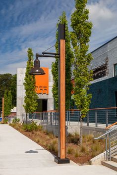 a street light sitting on the side of a road next to a tall metal pole