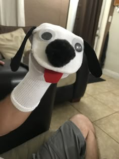 a person is holding up a dog head made to look like it's sticking its tongue out