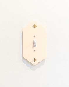 a white wall with a light switch on it's side and an outlet in the middle