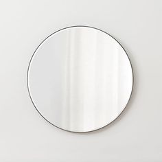 a round mirror mounted on the wall