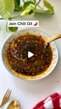 a spoon full of chili oil sitting on top of a white plate