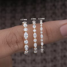 three pairs of diamond earrings are shown on someone's finger, with the size between them