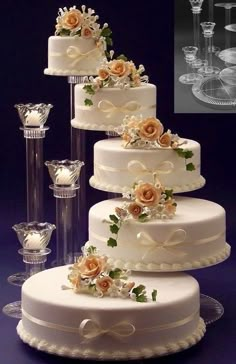 three tiered wedding cake with flowers and champagne glasses on the table next to it