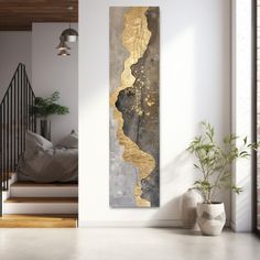 a painting hanging on the wall next to a plant in a room with white walls