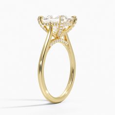 a yellow gold ring with an oval cut diamond in the center and side stones on each side