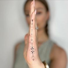 a woman is holding her hand up in the air with an intricate design on it