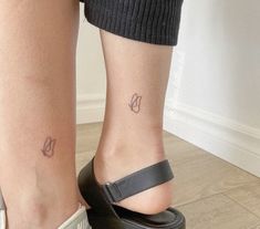 a woman's foot with two small tattoos on her left ankle and the other side of her leg