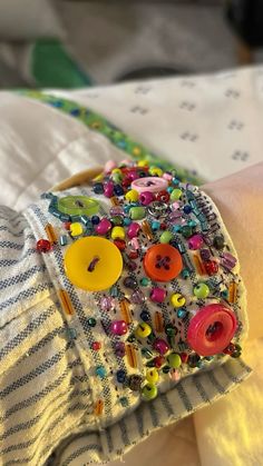 a close up of a person's arm wearing a bracelet with buttons on it