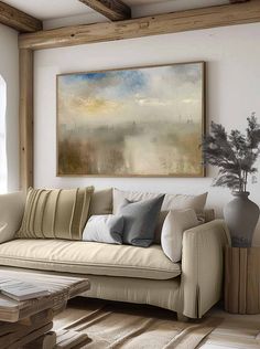 a living room filled with furniture and a painting on the wall above it's couch