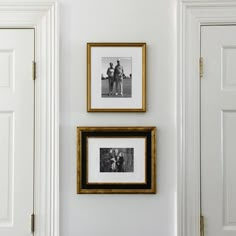 two framed pictures hang on the wall next to an open door in a white room