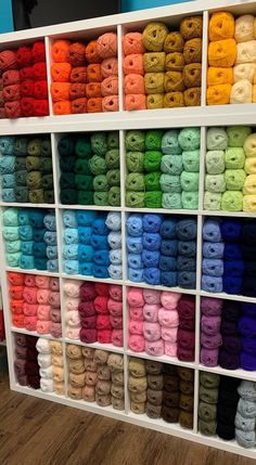 there are many different colors of yarn on the shelves